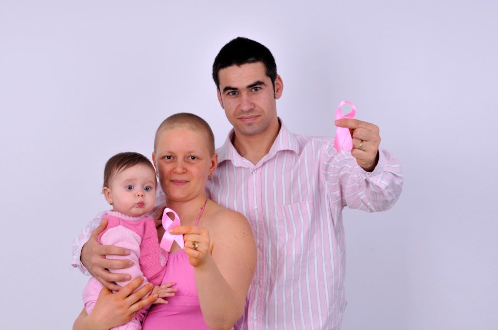 mother with cancer and her family holding a ribbon